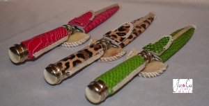 Cuchillos con cabos y vainas de cuero fantasía en simil serpiente, colores fucsia y verde manzana, y animal print. Terminaciones en alpaca y tiento.